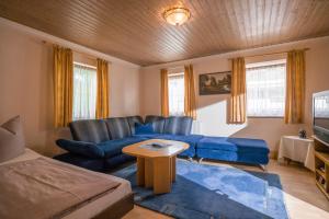 a living room with a blue couch and a table at Landgasthof Oberlander in Kirchbichl