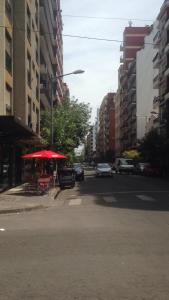 una strada cittadina vuota con un ombrello rosso e le auto di Terraza quincho y jacuzzi privados 4 personas a Mar del Plata