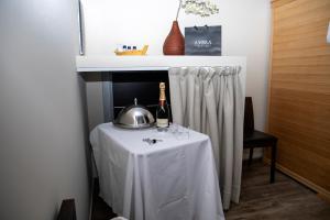 a table with a tea kettle and a bottle of wine at Castahotel in Guarene