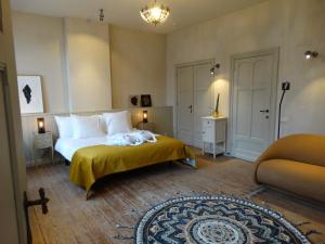 a bedroom with a large bed with a yellow blanket at The Chamberlain in Ieper