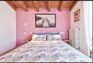 a bedroom with a bed with a pink wall at Terme al Lago - stanza privata in loft in Sirmione