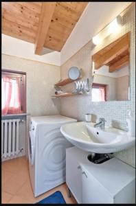a bathroom with a sink and a washing machine at Terme al Lago - stanza privata in loft in Sirmione