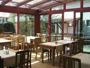 un restaurante con mesas y sillas de madera y ventanas en Gasthof Bogenrieder, en Waidhofen