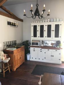 巴黎The Carriage House Flat - Downtown Paris Canada的带白色橱柜和水槽的厨房