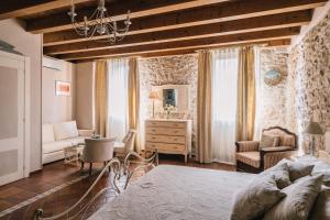 - une chambre avec un lit, une chaise et un bureau dans l'établissement B&B - Relais de charme la Caminella, à San Pietro in Cariano