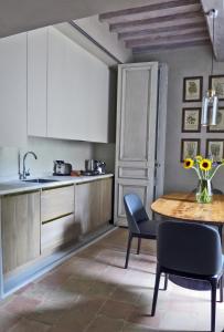 een keuken met een tafel en stoelen en een wastafel bij Stylish apartment in the historic center of Cortona in Cortona