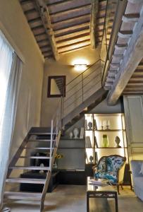 een wenteltrap in een kamer met een stoel en een trap bij Stylish apartment in the historic center of Cortona in Cortona