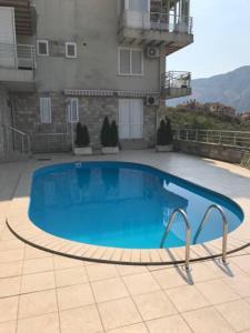 einem großen blauen Pool vor einem Gebäude in der Unterkunft Apartman Perovic in Kotor