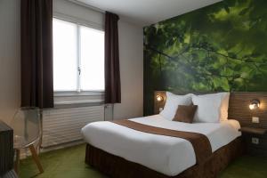 ブロンにあるThe Originals City, Hôtel Dau Ly, Lyon Est (Inter-Hotel)のベッドルーム1室(壁に絵画が描かれた大型ベッド1台付)