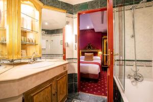 a bathroom with a double sink and a large mirror at Villa Opera Drouot in Paris