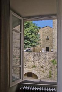 een raam met uitzicht op een stenen muur bij Stylish apartment in the historic center of Cortona in Cortona