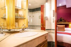 a bathroom with a sink, mirror, and bathtub at Villa Opera Drouot in Paris
