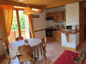 a kitchen with a table and chairs in a room at Résidence Chalet des Granges in Samoëns