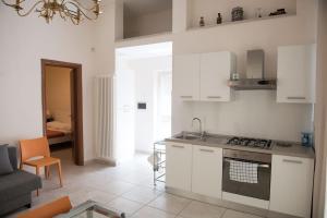 cocina con armarios blancos y fogones en Central Apartment - Residenza Battistessa en Caserta