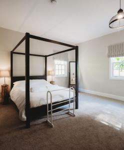 a bedroom with a black and white canopy bed at Orchard Cottage in St. Andrews