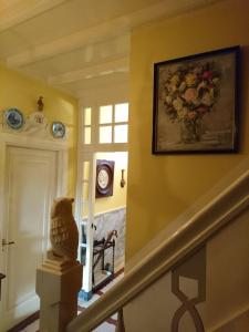 a staircase in a home with a vase of flowers on the wall at Deventer Heritage en Boutique B&B, museumhuis "De Worp", het huis met de theekoepel, logeren in authentiek historisch erfgoed in Deventer