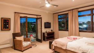 a bedroom with a bed and a chair and a window at Manor 38 in Port Elizabeth