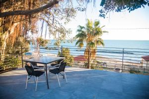 - une table et des chaises sur une terrasse donnant sur l'océan dans l'établissement Terramata Resort Case Vacanza, à Santo Stefano al Mare