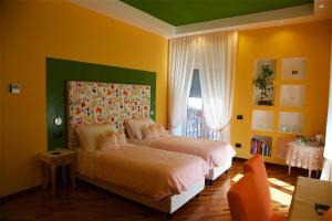 2 camas en un dormitorio con paredes amarillas en Il Giardino Segreto en Sorrento