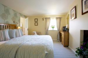 a bedroom with a large bed and a window at The Royal Oak Inn in Chichester