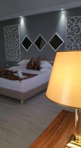 a bedroom with a bed and a lamp at Hotel Helin Aeroport - Craiova in Craiova