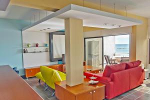 uma sala de estar com um sofá vermelho e cadeiras amarelas em Morpheus em Limassol