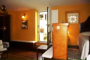 a bedroom with orange walls and a bed and a window at Casa das Calhetas - Turismo de Habitação in Calhetas