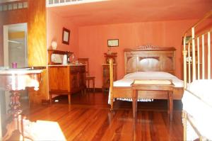Schlafzimmer mit einem Bett und einem Holztisch in der Unterkunft Casa das Calhetas - Turismo de Habitação in Calhetas