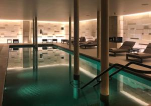 a swimming pool in a building with a lobby at The Lamp Hotel & Spa in Norrköping