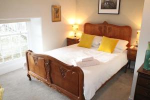 スカーバラにあるWest Hillのベッドルーム1室(大型木製ベッド1台、黄色い枕付)