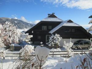 una casa cubierta de nieve con un coche aparcado delante en Apartment Sunnseitn am Verditz, en Verditz