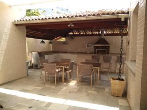 a patio with a table and chairs and a kitchen at 01 Quadra da Praia in Riviera de São Lourenço