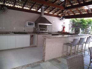 a kitchen with a counter with stools and a stove at 01 Quadra da Praia in Riviera de São Lourenço