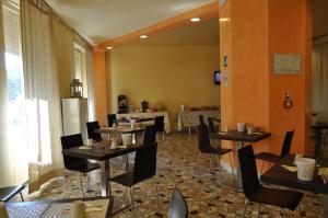 a restaurant with tables and chairs in a room at Guerrini Hotel in Castiglioncello
