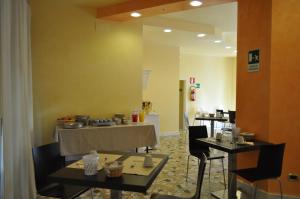 a dining room with a table and chairs and a mirror at Guerrini Hotel in Castiglioncello