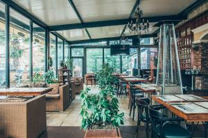 a restaurant with tables and chairs and plants at Hotel Super 8 in Skopje
