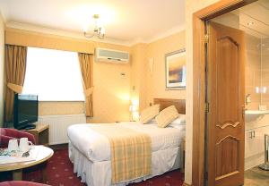 a hotel room with a bed, desk, and chair at Leapark Hotel in Grangemouth