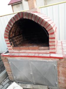 an outdoor brick oven with a metal door at Pensiunea SENA Focsani in Focşani +10 photos