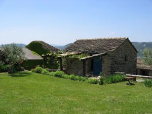 una casa de piedra en un campo de césped verde en La Era, en Aínsa