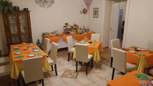 un comedor con mesas y sillas de color naranja en Palazzo 1892 Guest House, en Castelvetere in Val Fortore