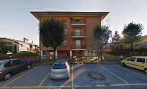 un estacionamiento con autos estacionados frente a un edificio en VILLA FENIX PONTE SAN PIETRO, en Ponte San Pietro