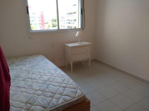 a bedroom with a bed and a dresser and a window at 01 Quadra da Praia in Riviera de São Lourenço +37 photos