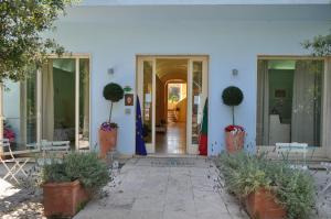 a white building with plants in front of it at Guerrini Hotel in Castiglioncello