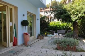 a building with a patio with chairs and a table at Guerrini Hotel in Castiglioncello