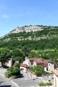 uitzicht op een dorp met een berg op de achtergrond bij Auberge de La Fontaine in Autoire