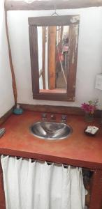 ein Waschbecken mit einem Spiegel auf der Theke in der Unterkunft Cabaña del Cielito - Complejo El Taller in Potrerillos