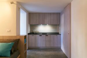 uma cozinha com armários de madeira e um sofá num quarto em Casadina em Camaiore