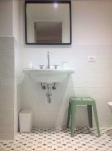uma casa de banho com um lavatório e um banco verde em Casadina em Camaiore