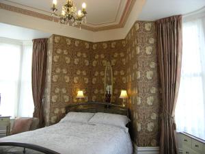 a bedroom with a bed and a chandelier at Christleton House in Llandudno