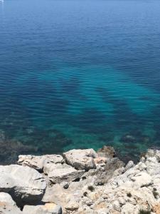 a large body of water with rocks in the foreground at Domus Orestea Luxury Suites in Palermo